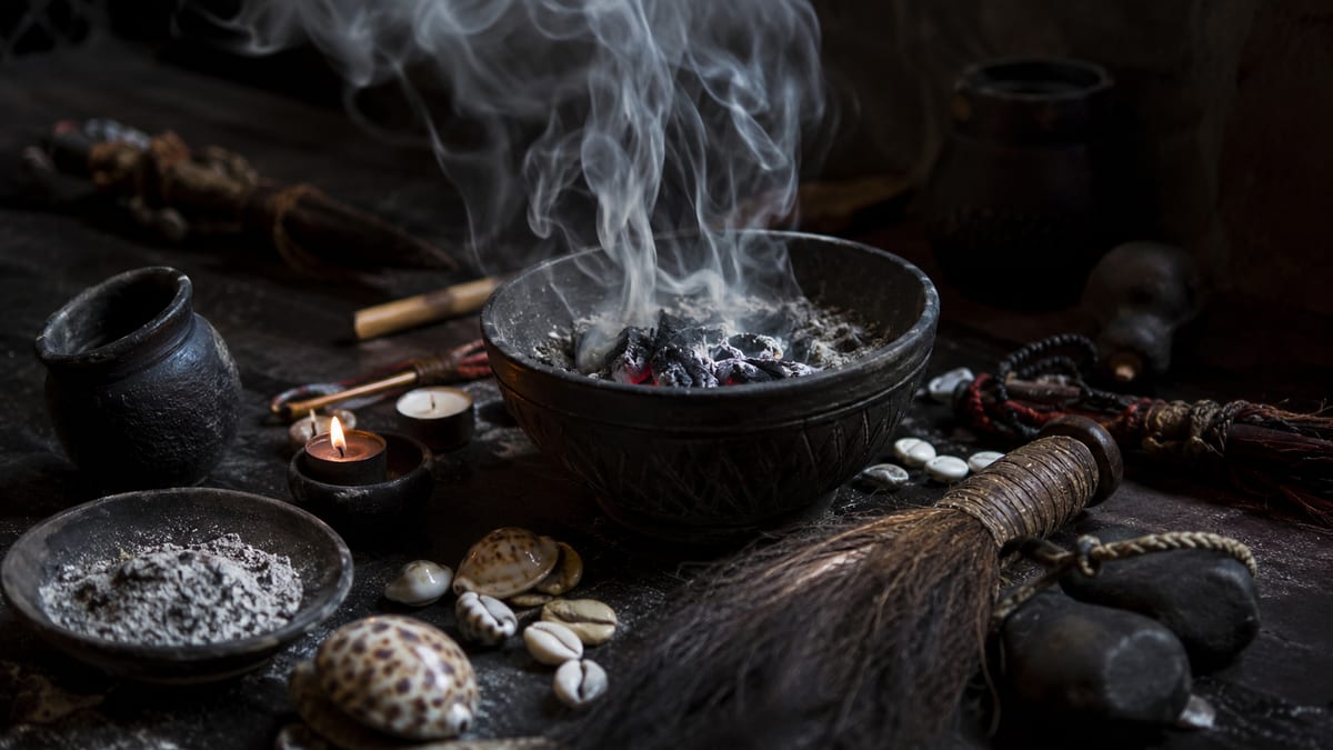 Brasero fumant entouré de cauris et d'outils de rituel